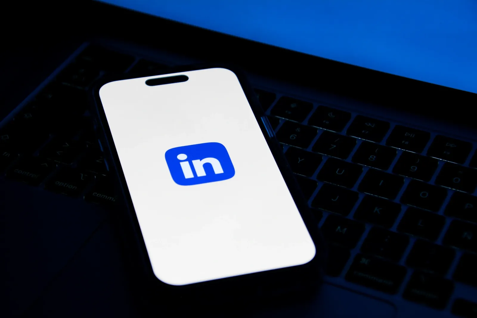 Smartphone affichant le logo LinkedIn posé sur un clavier d'ordinateur portable